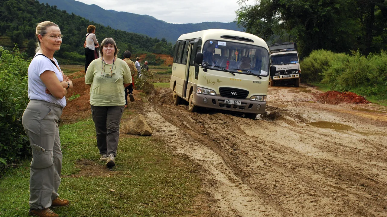 Un minibus et un camion avancent sur une route boueuse près de Bắc Hà, au lendemain des fortes pluies de 2008.