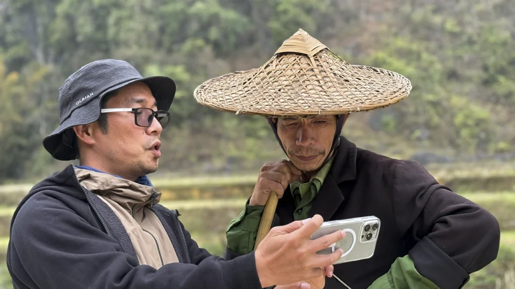 Thuấn, guide francophone au Vietnam, échange avec un habitant en plein air.