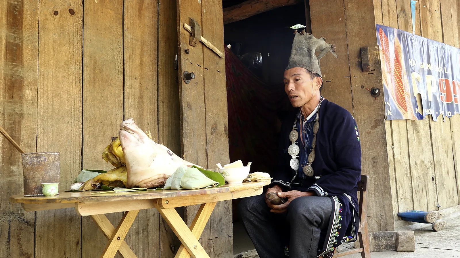 Au détour d’un virage Un maître rituel Dao Tiền assis devant une table d'offrandes, sur la route de Ba Bể.