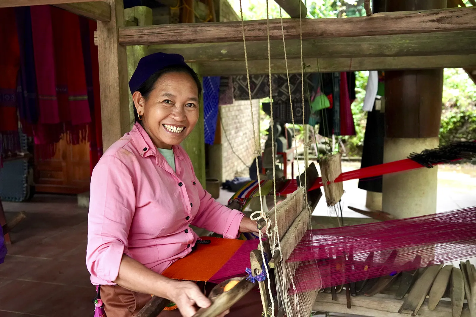 Derrière le métier à tisser Une femme thaïe travaille sur un métier à tisser traditionnel sous une maison sur pilotis à Bản Đôn, Pù Luông.
