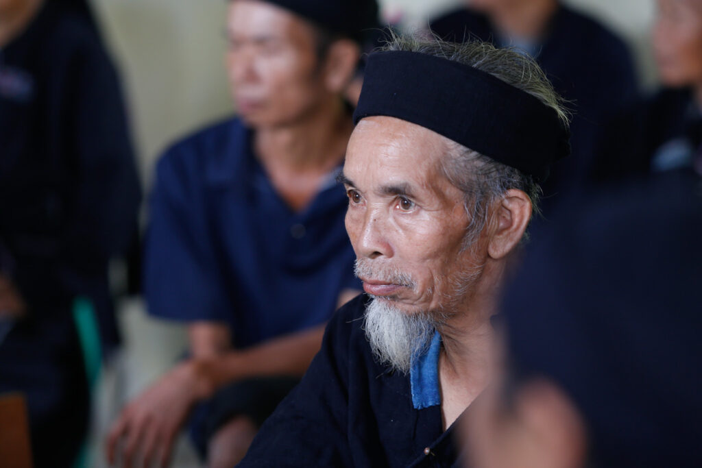 Portrait d’un homme La Chí à Bản Phùng, portant un couvre-chef noir et une barbiche blanche.