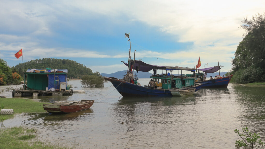 Bateaux de pêche en bois et petites barques près du rivage de l’île de Quan Lạn.
