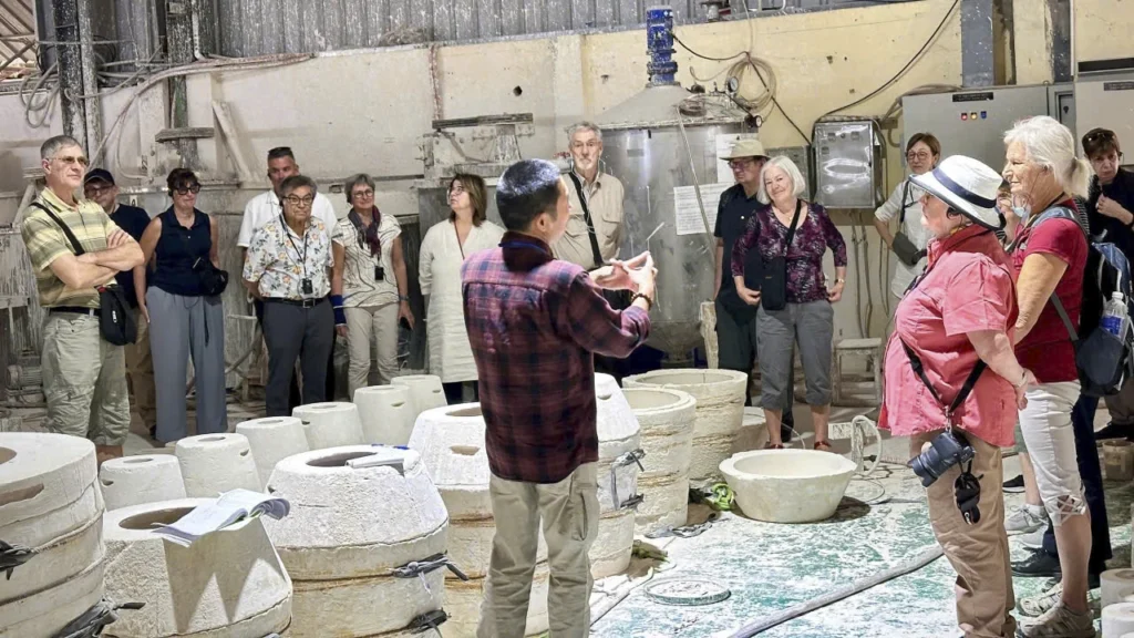 Thuấn explique le travail d'un atelier à un groupe de voyageurs au Vietnam.