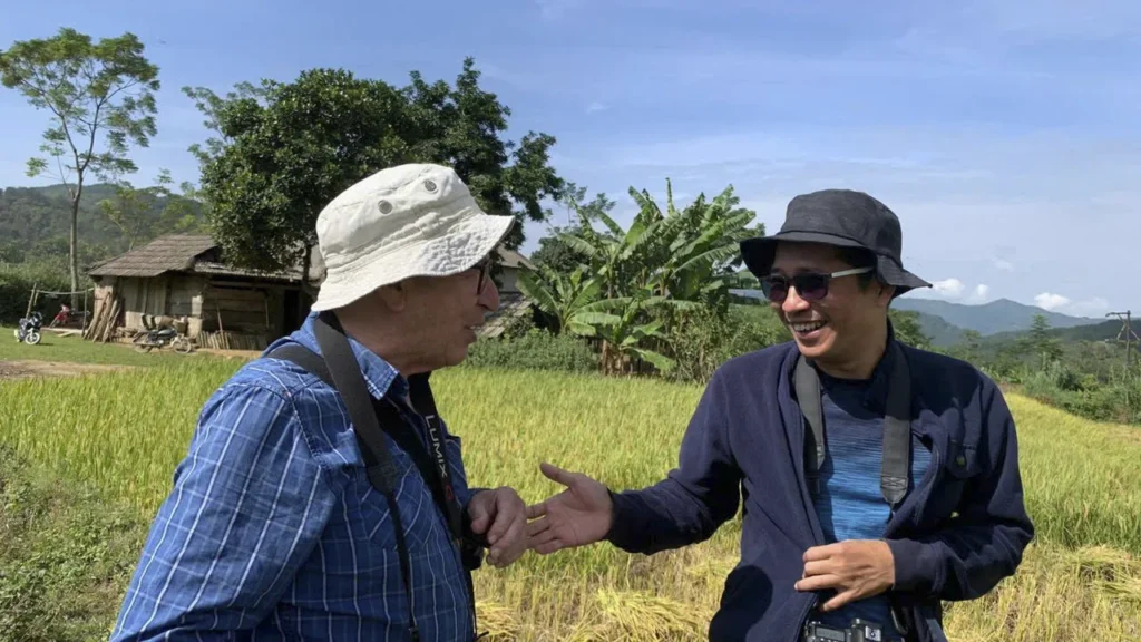 Thuấn échange avec Denis au bord d'une rizière au Vietnam.