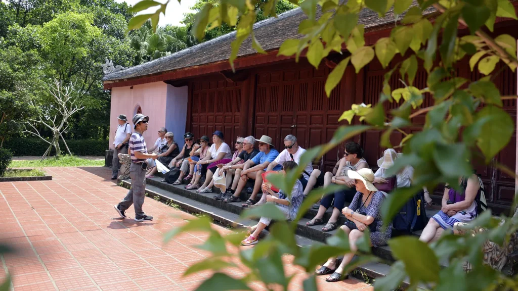 Thuấn guide un groupe dans le jardin derrière la pagode Thiên Mụ à Huế.